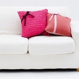 Светлый диван с красными подушками